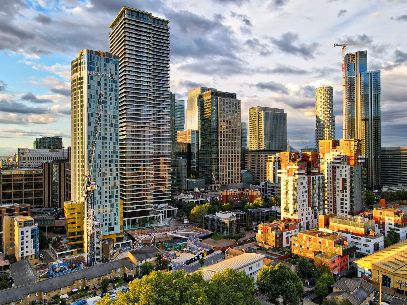 Dramatic view of modern skyscrapers in Canary Wharf, an iconic financial district in London at sunset.